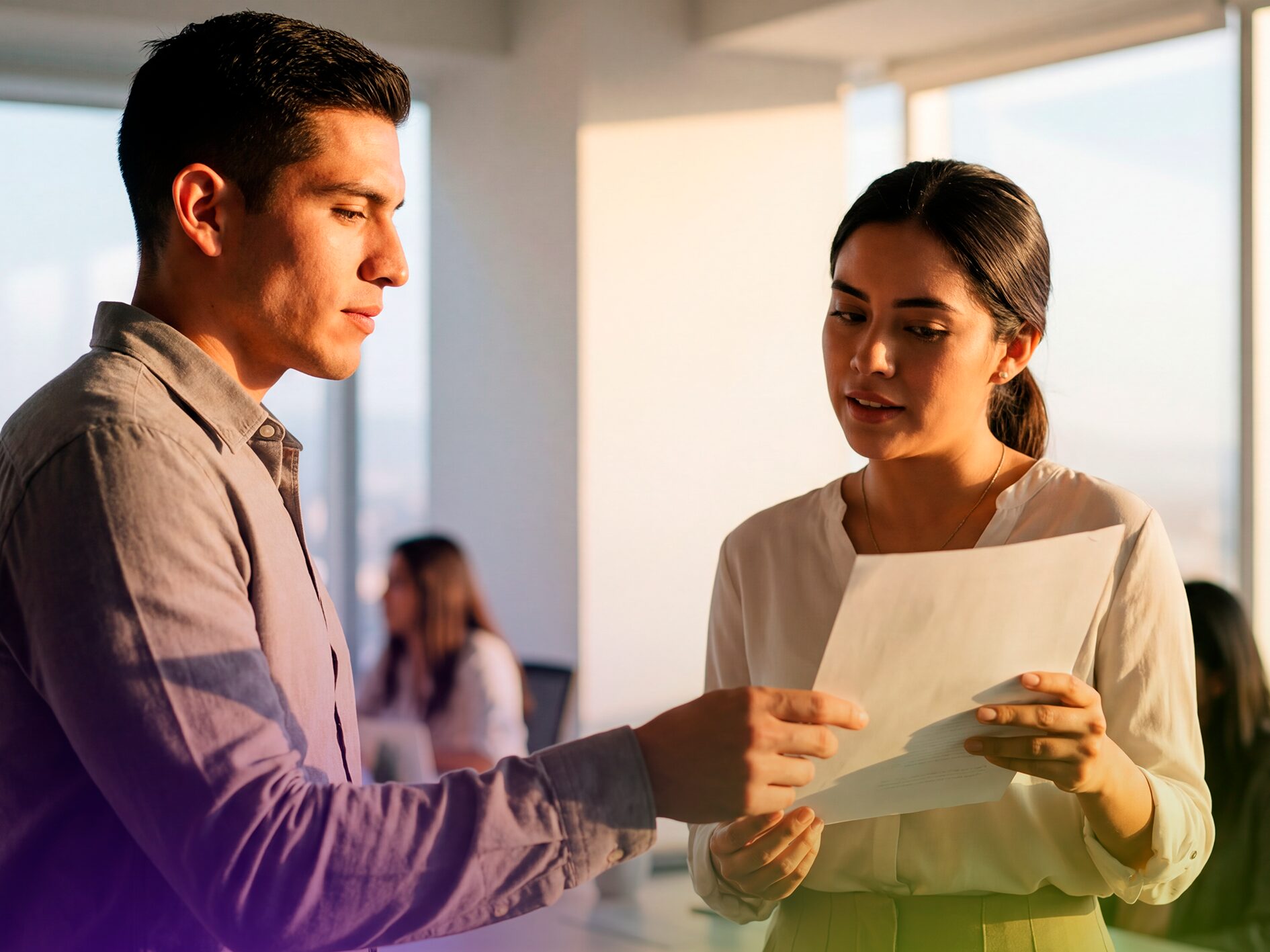 Dos colegas profesionales en una oficina revisando documentos de la certificación de inglés CENEVAL-Platzi.
