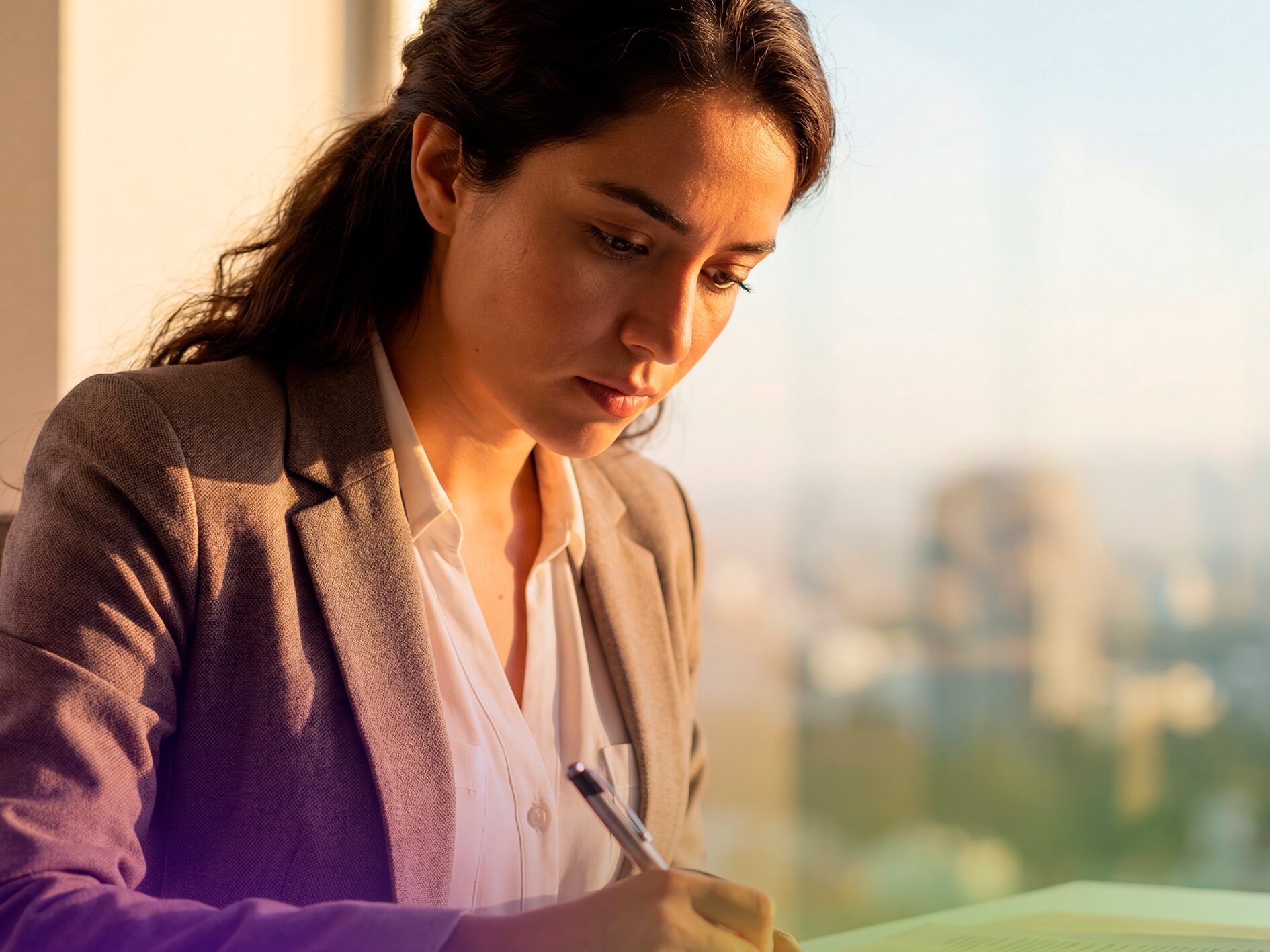 Primer plano de una mujer profesional concentrada tomando notas para su evaluación de inglés.